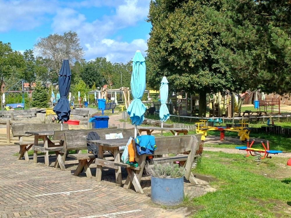 Terras met picknicktafels bij het clubgebouw
