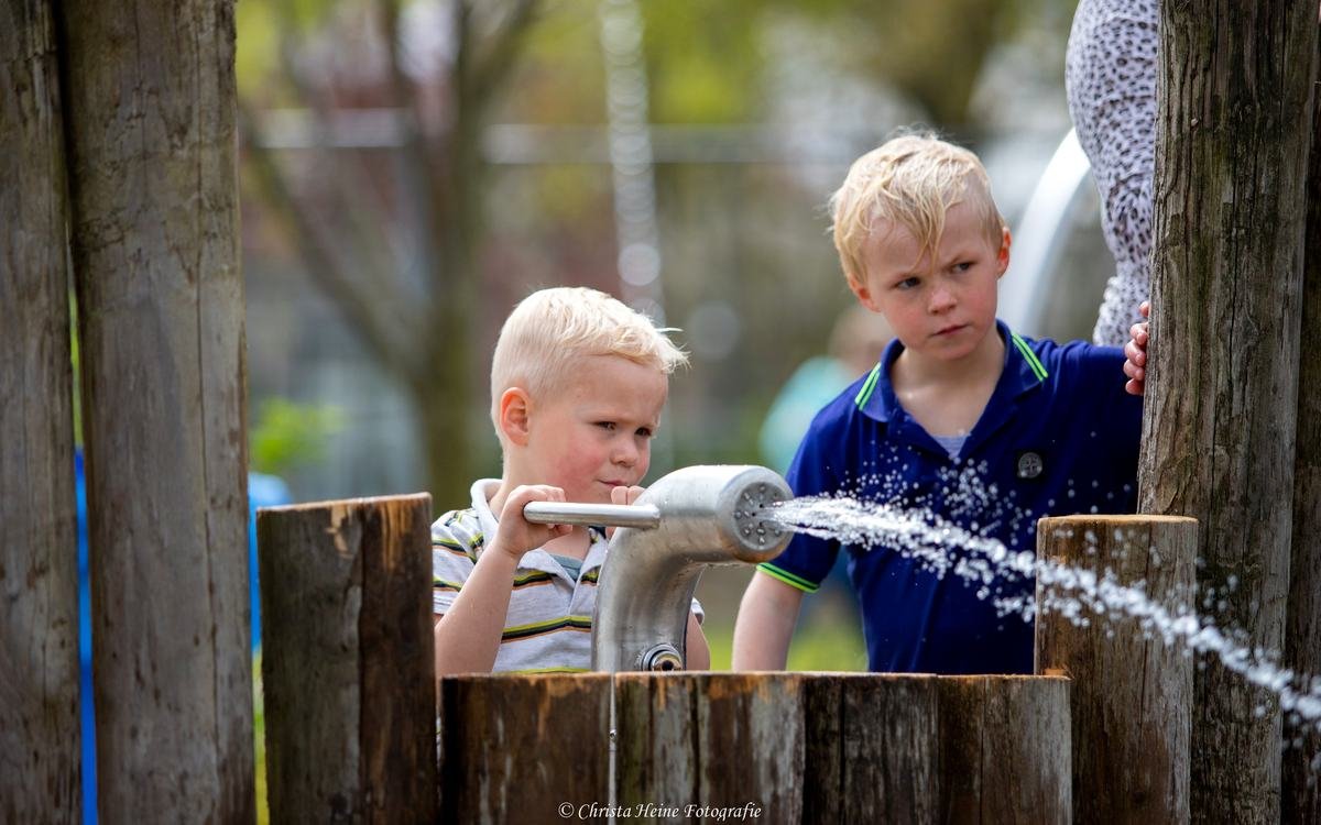 Kinderen pompen water in het waterdorp